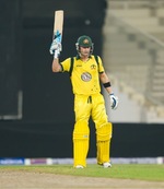 Michael Clarke raises his bat after completing his fifty