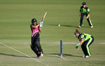 Sara McGlashan of New Zealand hits out with Mary Waldron of Ireland looking on