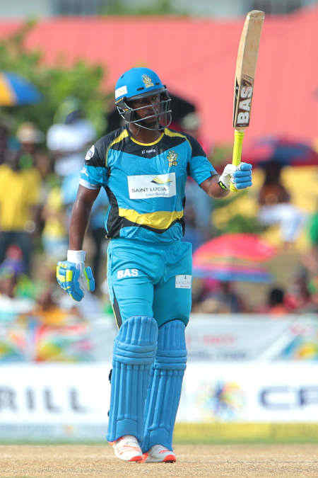J Charles raises his bat after scoring a fifty